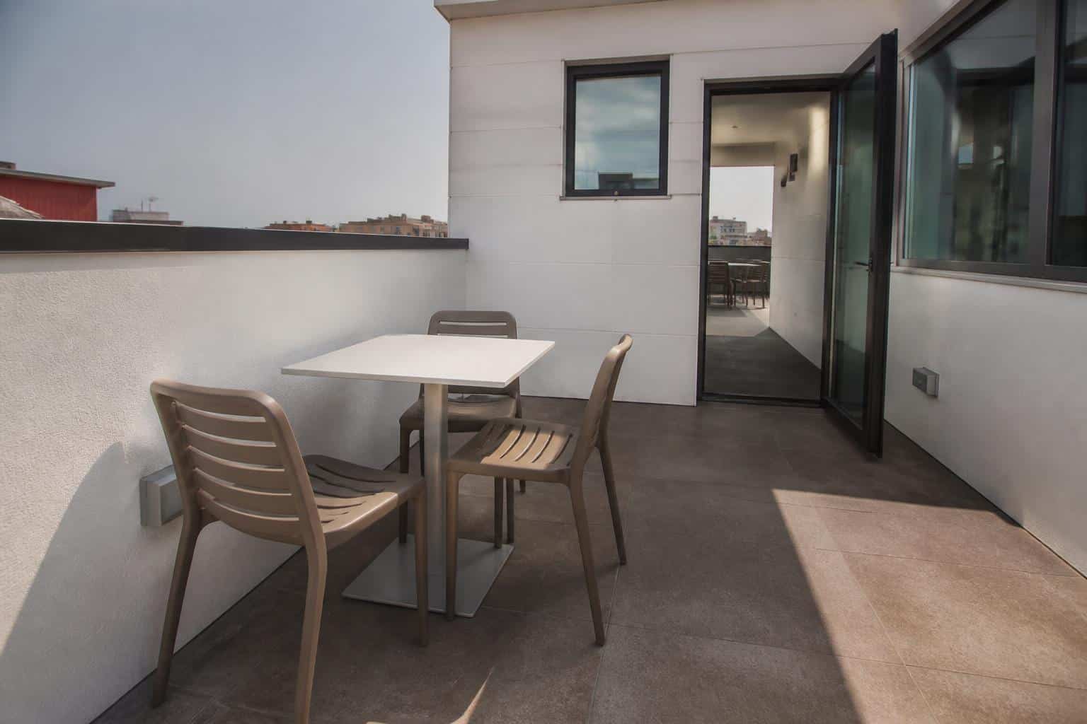 Compact rooftop cafe seating near a clear doorway